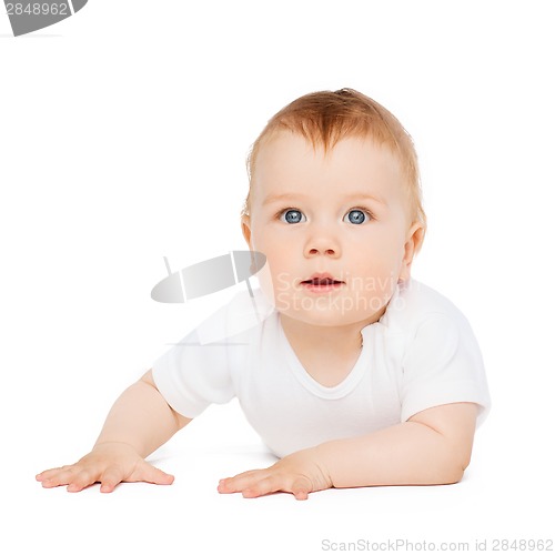 Image of smiling baby lying on floor and looking up