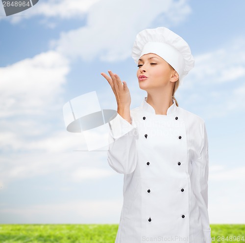 Image of smiling female chef showing delicious sign