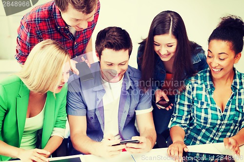 Image of students looking into smartphone at school