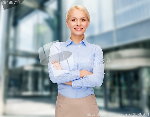 Image of young smiling businesswoman with crossed arms