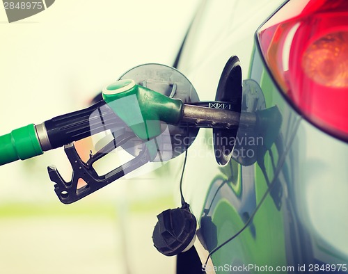 Image of pumping gasoline fuel in car at gas station