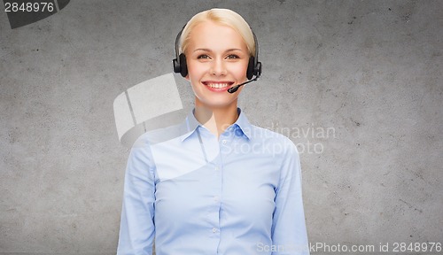 Image of friendly female helpline operator with headphones