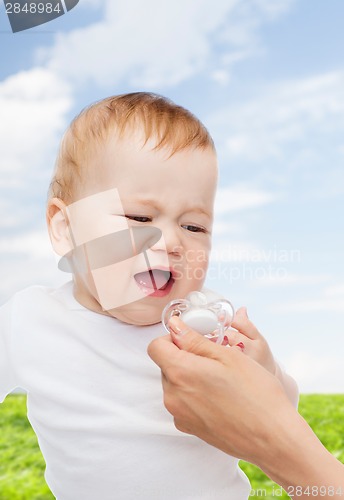 Image of crying baby with dummy