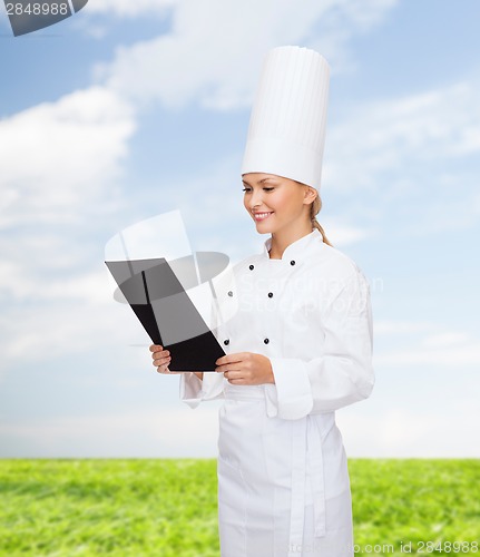 Image of smiling female chef with black blank paper