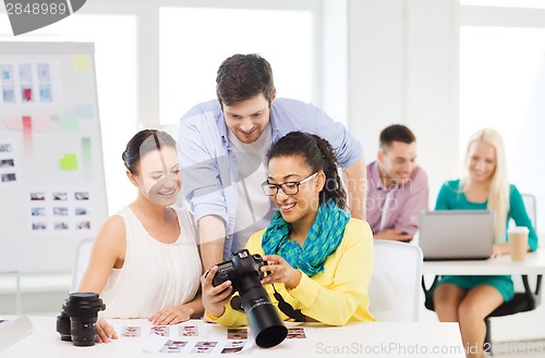 Image of smiling team with photocamera working in office