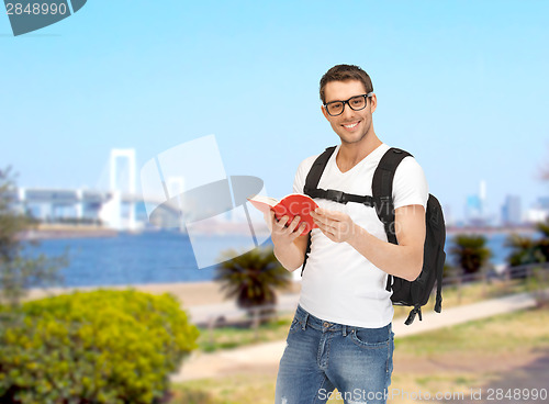 Image of travelling student with backpack and book