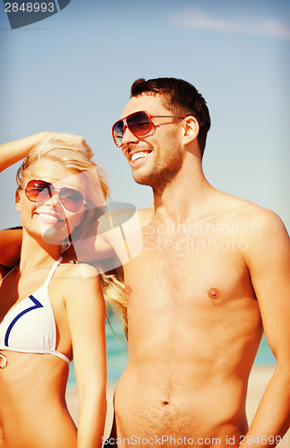 Image of happy couple in sunglasses on the beach