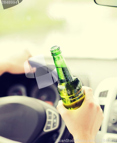 Image of man drinking alcohol while driving the car