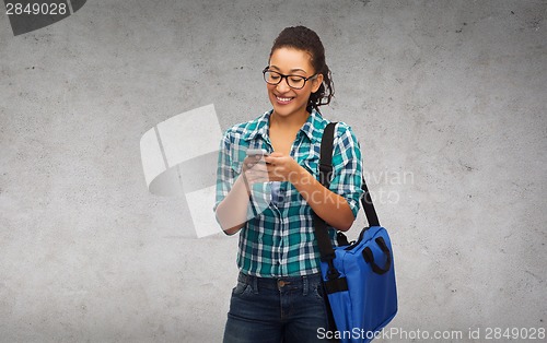 Image of student in eyeglasses with smartphone and bag