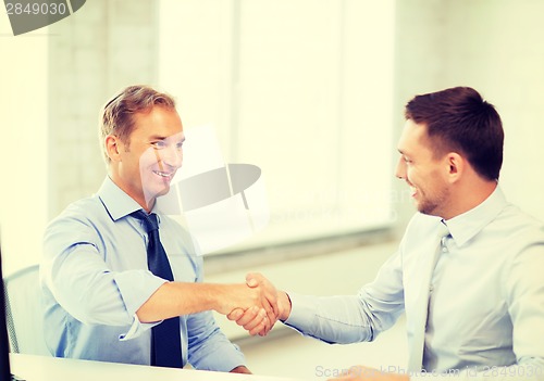 Image of businessmen shaking hands in office