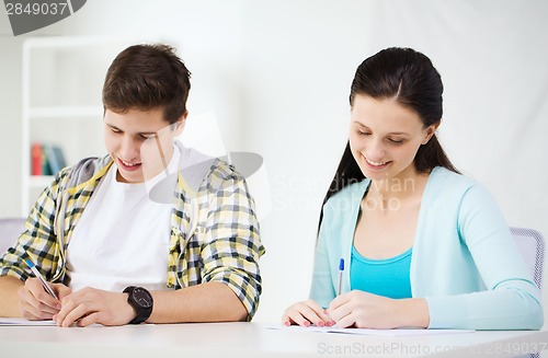 Image of smiling students with textbooks at school