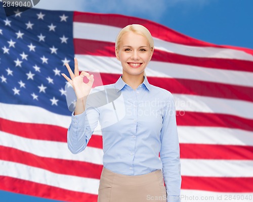 Image of smiling businesswoman showing ok-sign with hand