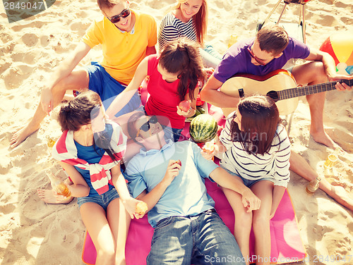 Image of group of friends having fun on the beach