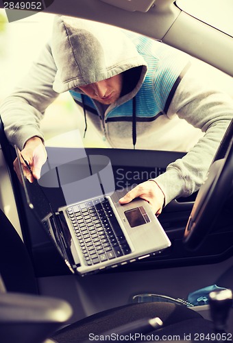 Image of thief stealing laptop from the car