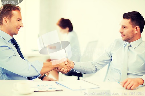 Image of businessmen shaking hands in office