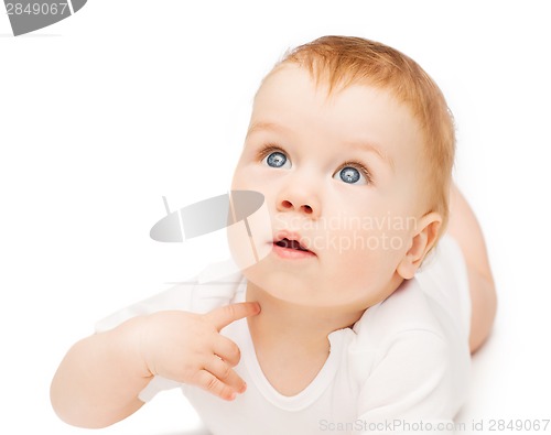 Image of curious baby lying on floor and looking up