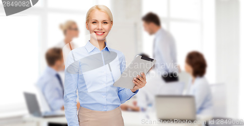 Image of smiling woman looking at tablet pc computer