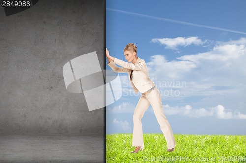 Image of businesswoman pushing away concrete wall