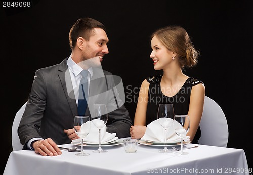 Image of smiling couple looking at each other at restaurant
