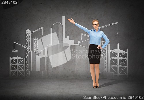 Image of smiling businesswoman in glasses pointing her hand