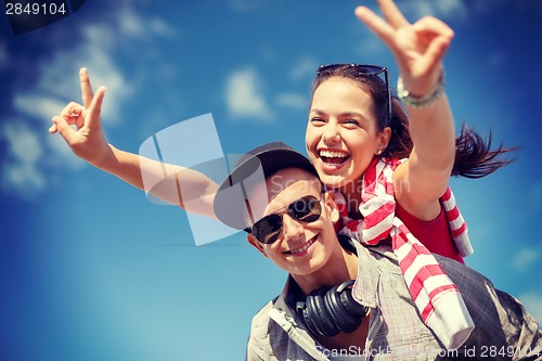 Image of smiling teenagers in sunglasses having fun outside
