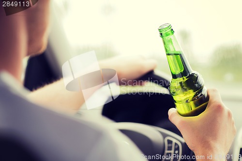 Image of man drinking alcohol while driving the car