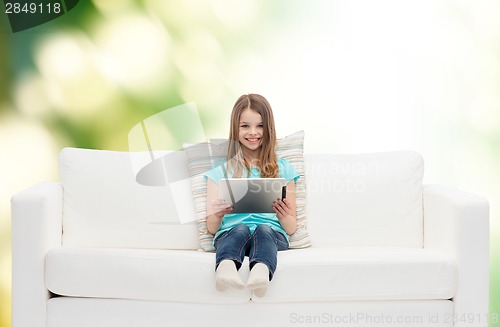 Image of little girl sitting on sofa with tablet pc