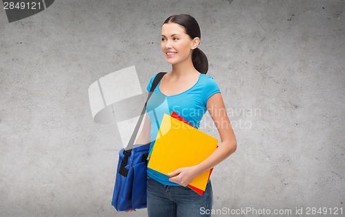Image of smiling female student with bag and folders