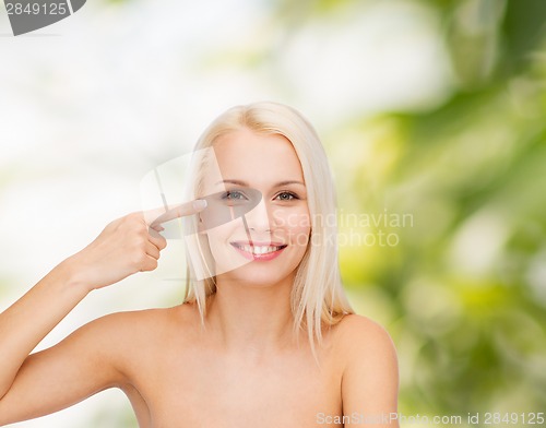 Image of beautiful woman touching her eye area