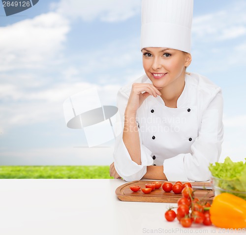 Image of smiling female chef with vegetables