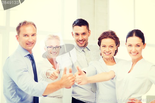 Image of business team showing thumbs up in office