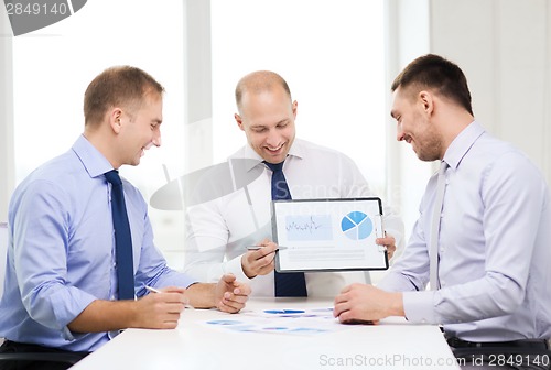 Image of smiling businessmen with papers in office