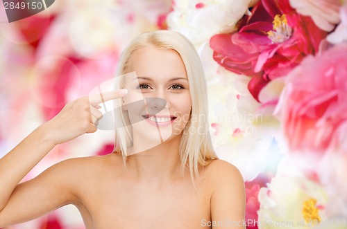 Image of beautiful woman touching her eye area