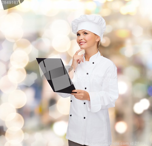 Image of smiling female chef with black blank paper