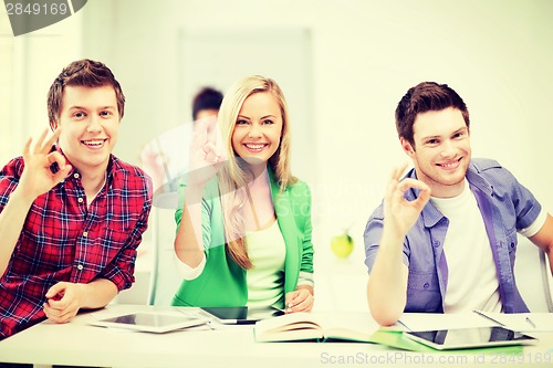 Image of students with tablet pcs showing ok sign