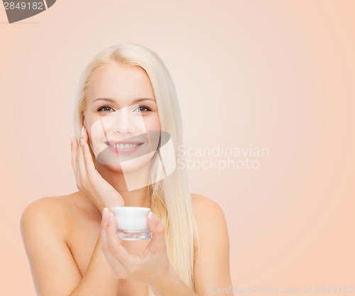 Image of woman applying cream on her skin