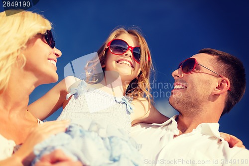 Image of happy family in sunglasses over blue sky