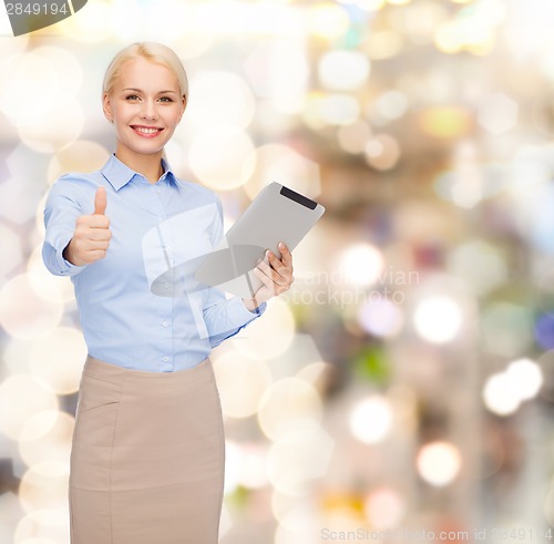 Image of smiling woman looking at tablet pc computer