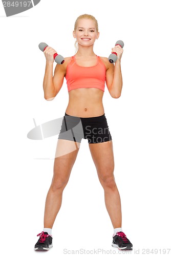 Image of smiling beautiful sporty woman with dumbbells