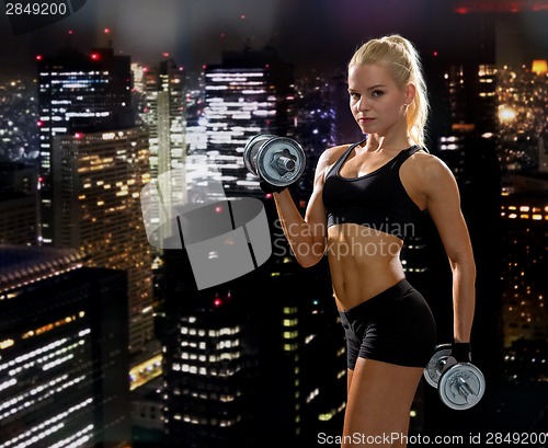 Image of sporty woman with heavy steel dumbbells