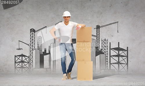 Image of man in helmet with tower of cardboard boxes