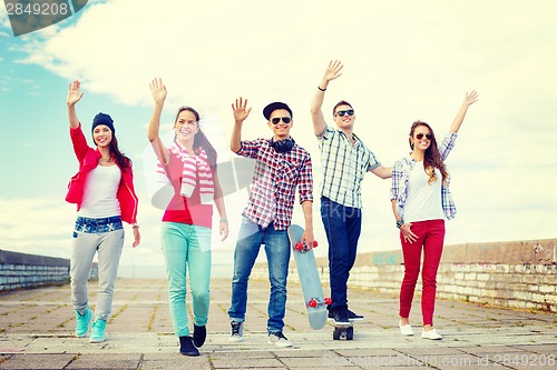 Image of group of smiling teenagers waving hands
