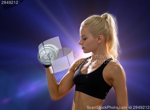 Image of young sporty woman with heavy steel dumbbell