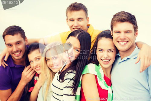 Image of group of friends having fun on the beach