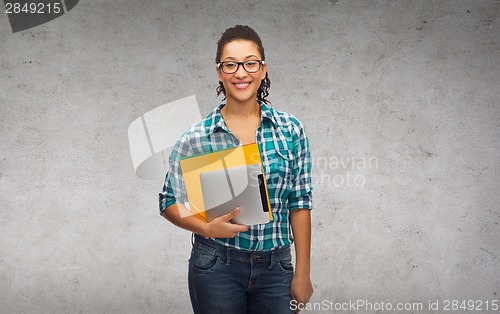 Image of student in eyeglasses with folders and tablet pc