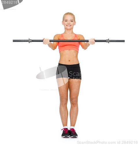 Image of smiling sporty woman exercising with barbell