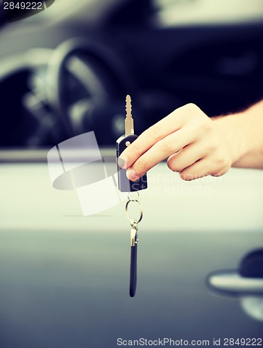 Image of man with car key outside