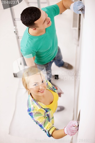 Image of smiling couple doing renovations at home