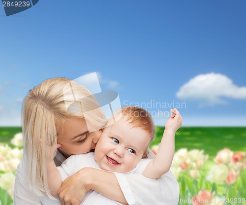 Image of happy mother kissing smiling baby