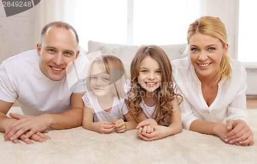 Image of parents and two girls lying on floor at home
